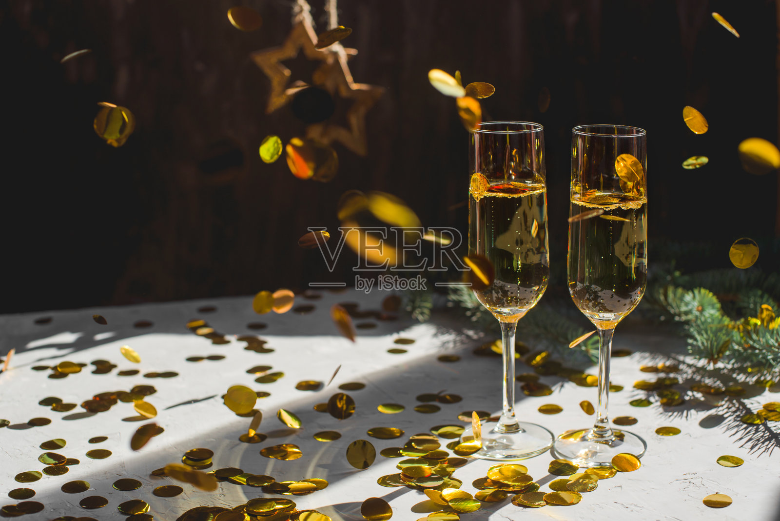 两杯金色纸屑的香槟。照片摄影图片