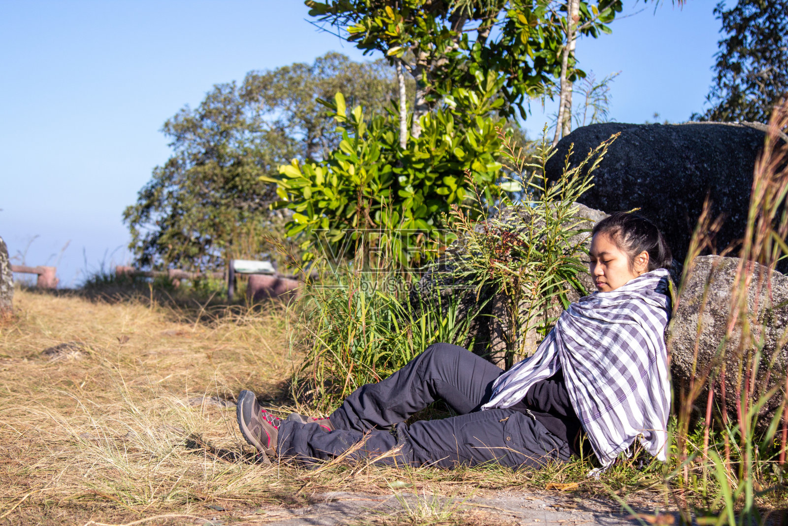 登山女子在日出的山崖上，在大自然中休息。胖女人户外。胖女人在山上休息。在自然中放松的概念。享受。照片摄影图片
