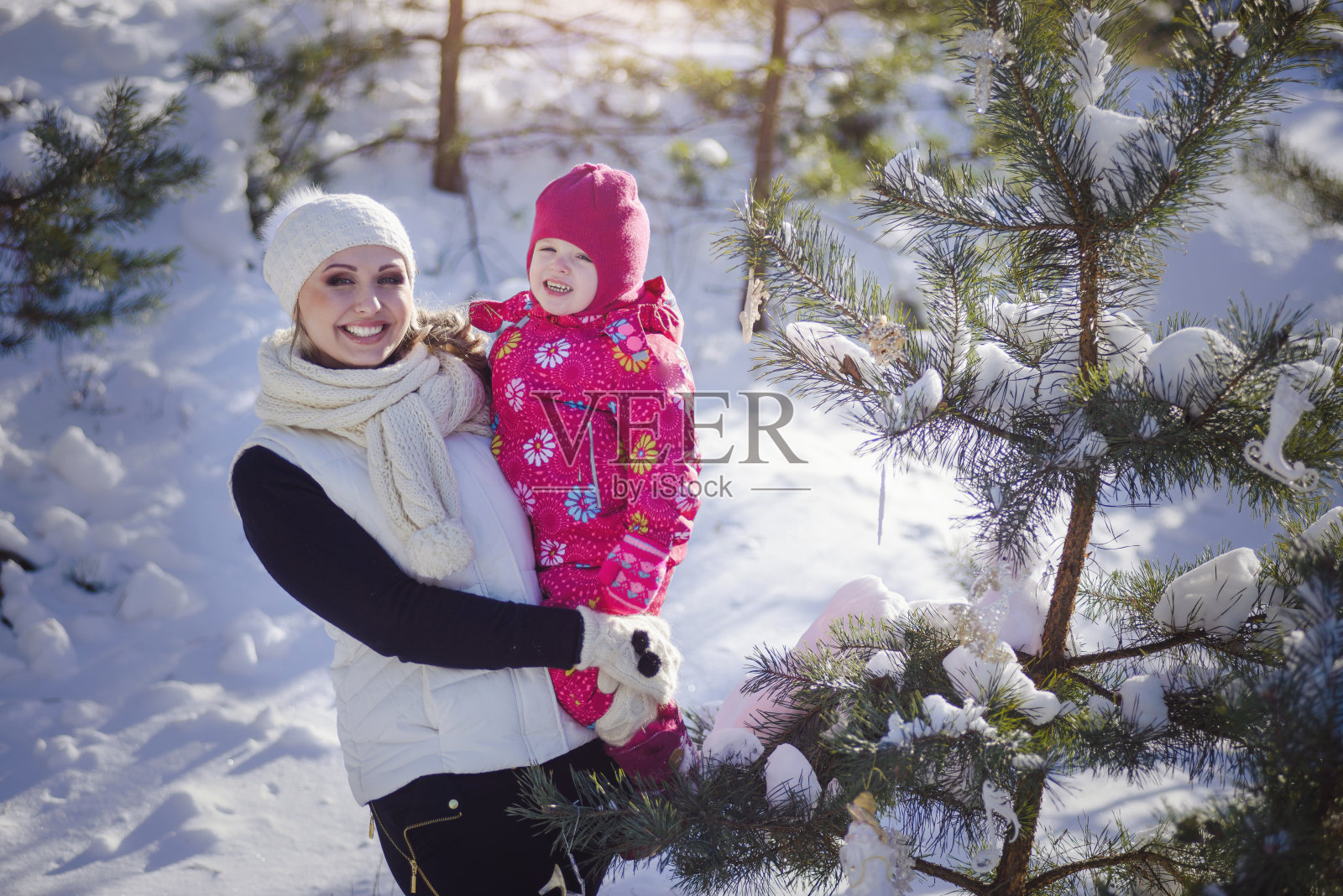 年轻的母亲和她的小女儿在户外享受美丽的冬日照片摄影图片