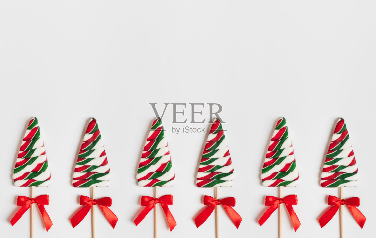 圣诞节边界与糖果的形状的圣诞树在一个白色的背景。照片摄影图片