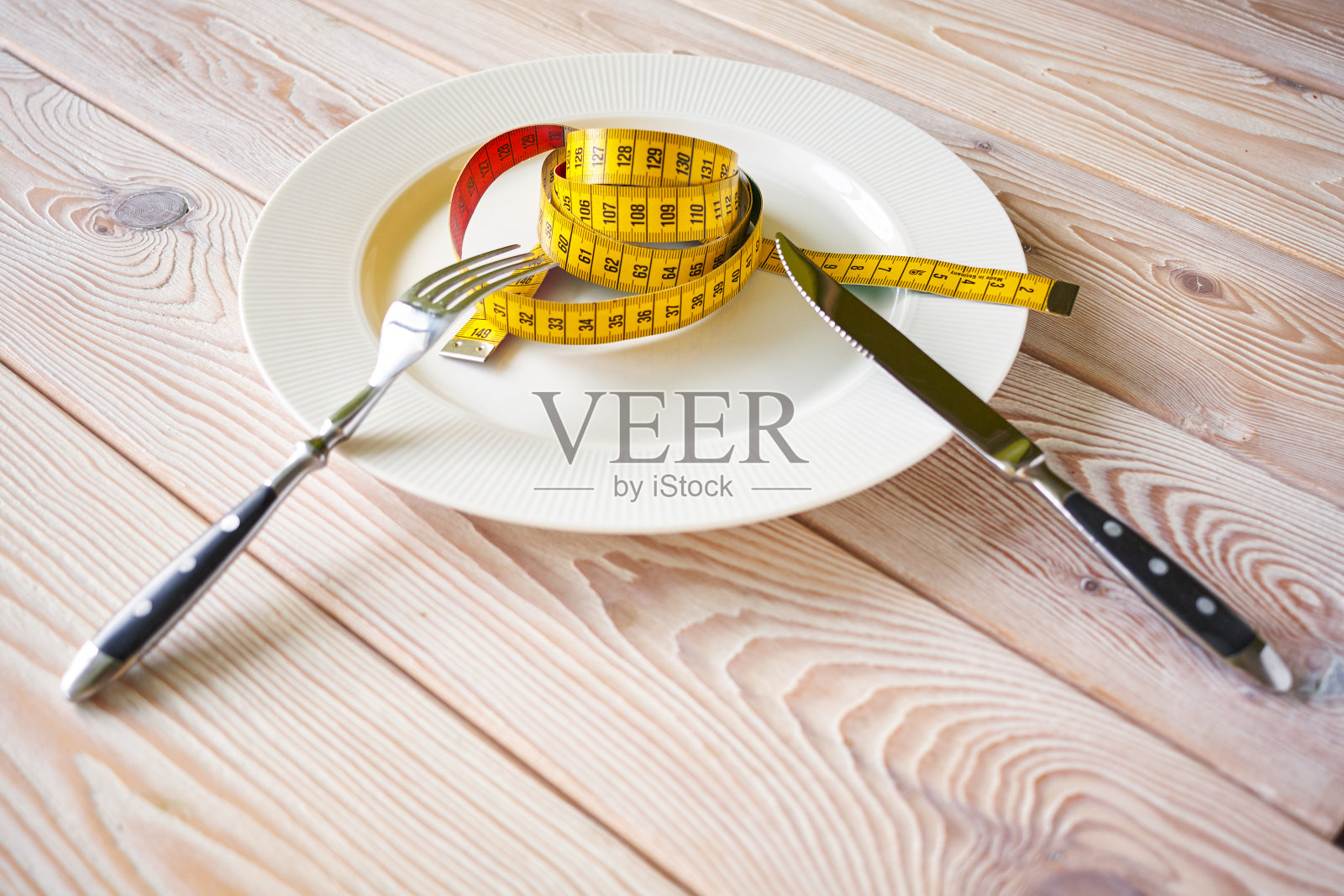 在白色底片上拍摄卷尺。节食概念形象。饮食而不是食物。照片摄影图片