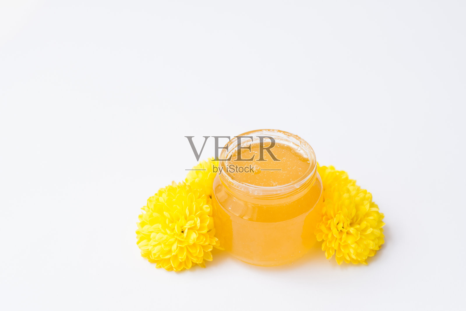 蜂蜜罐与花孤立在白色背景，复制空间照片摄影图片