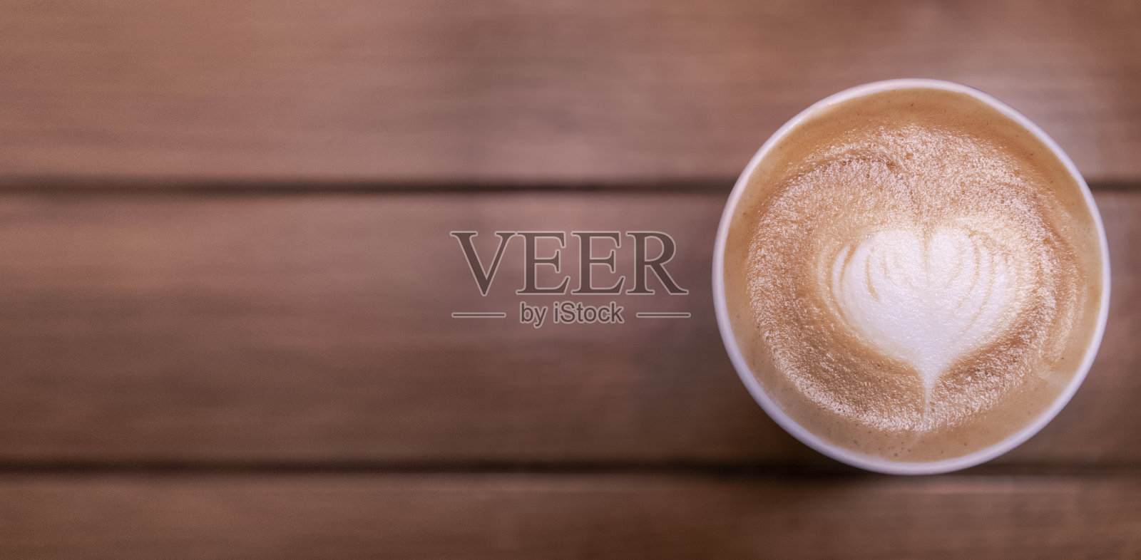 木桌上放着一杯拿铁咖啡照片摄影图片
