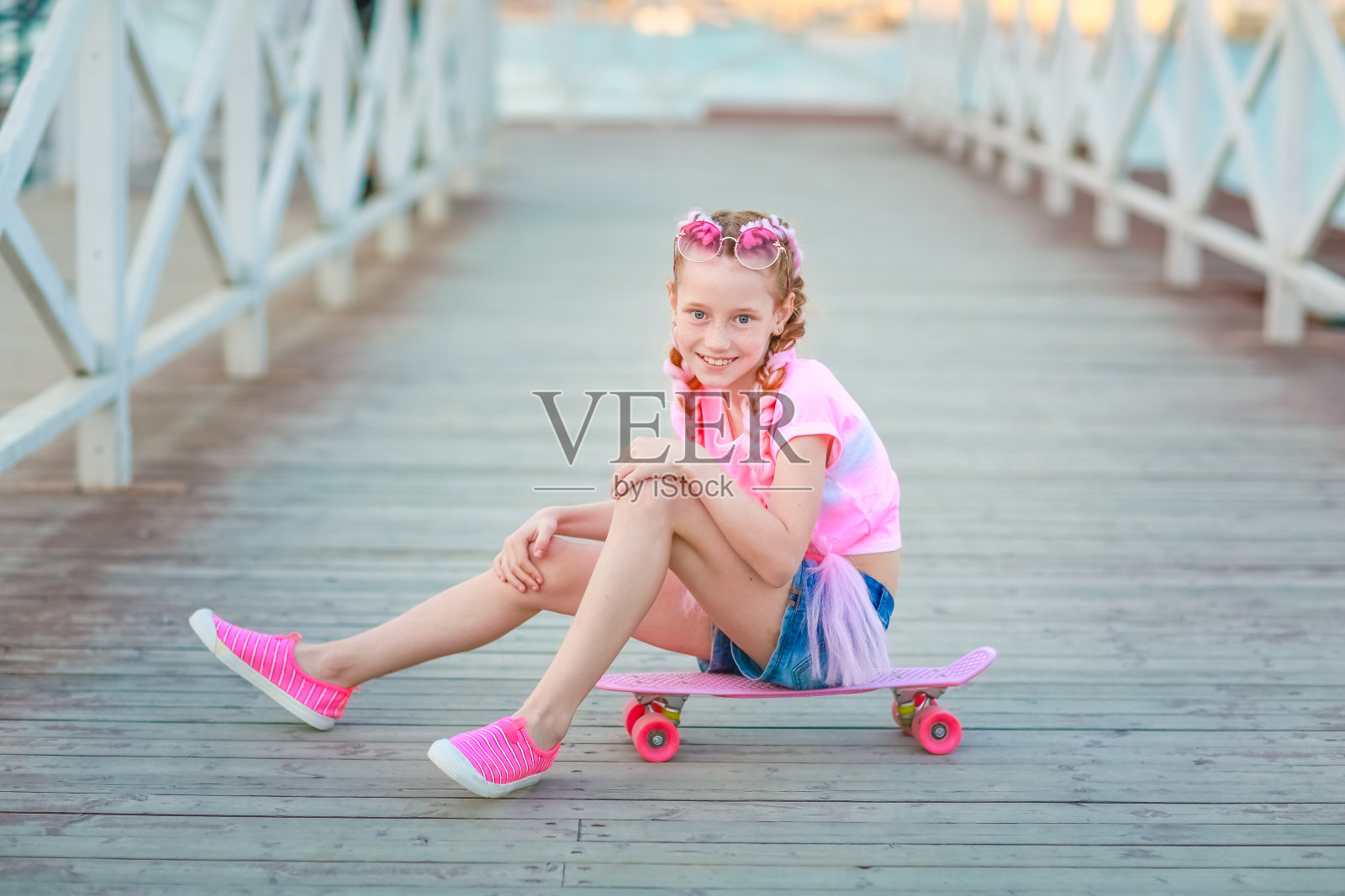 孩子厌倦了活跃的户外游戏，坐下来休息照片摄影图片