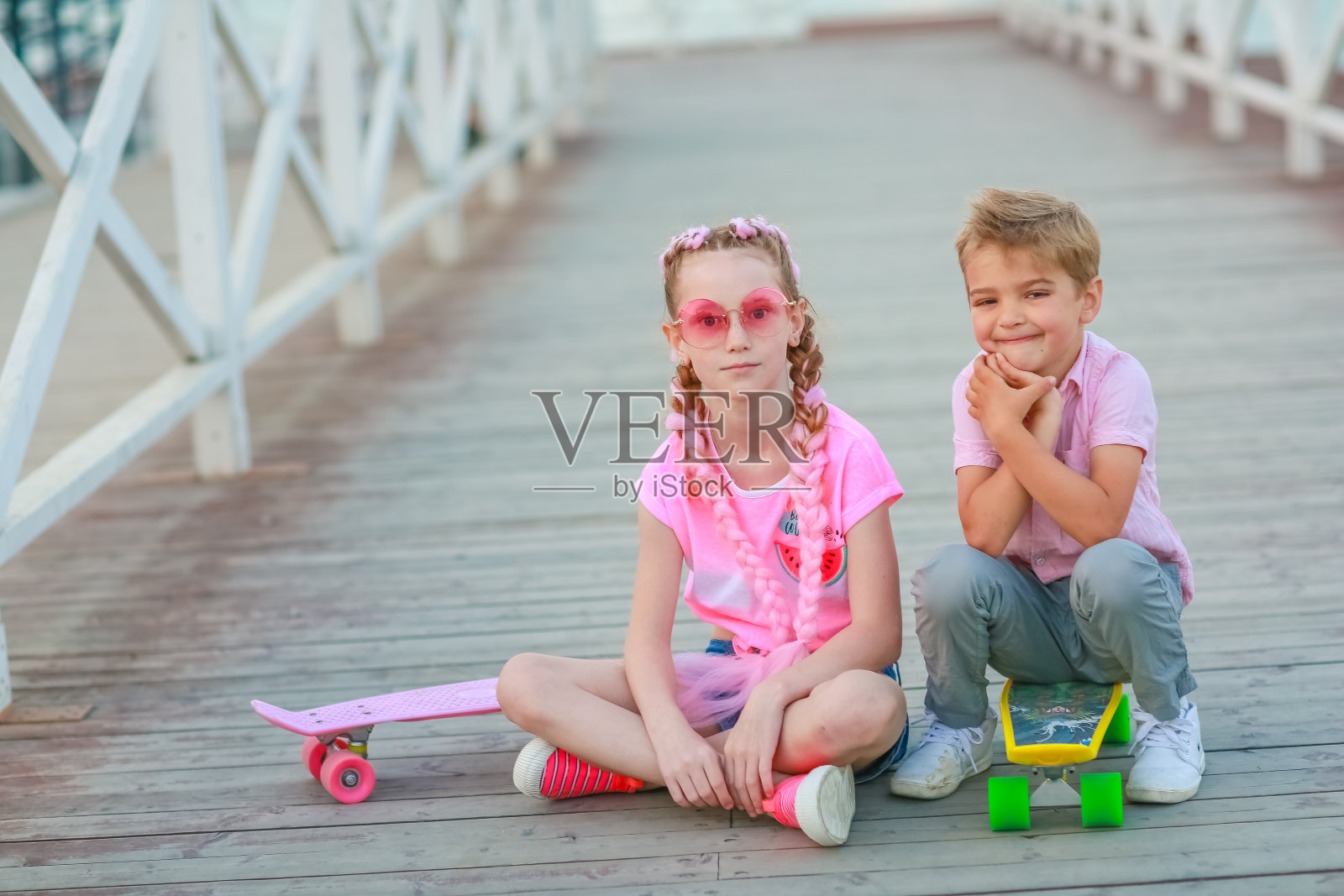 弟弟和妹妹穿着粉红色的t恤一起在公园里散步照片摄影图片