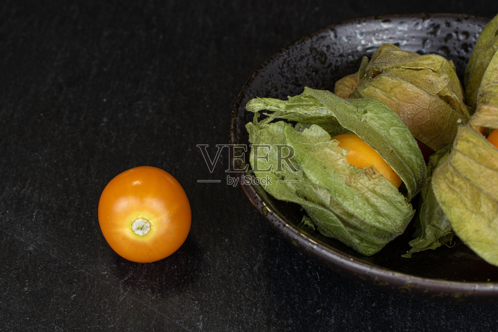 灰色的石头上有新鲜的橙色酸浆照片摄影图片