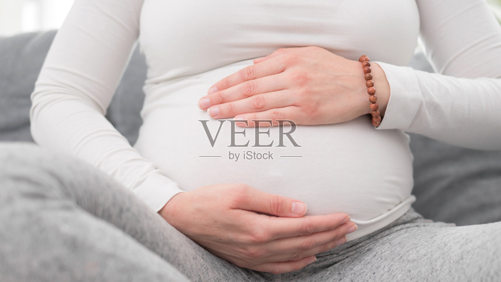 疲惫的孕妇在家中沙发上休息，有胃部不适。照片摄影图片