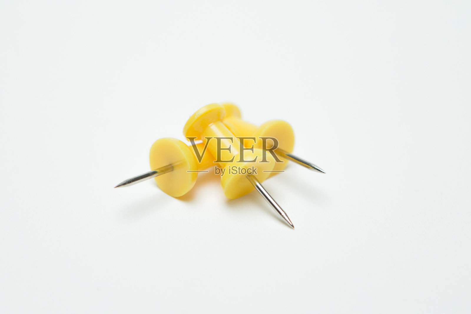 黄色大头针在白色背景上的特写照片摄影图片