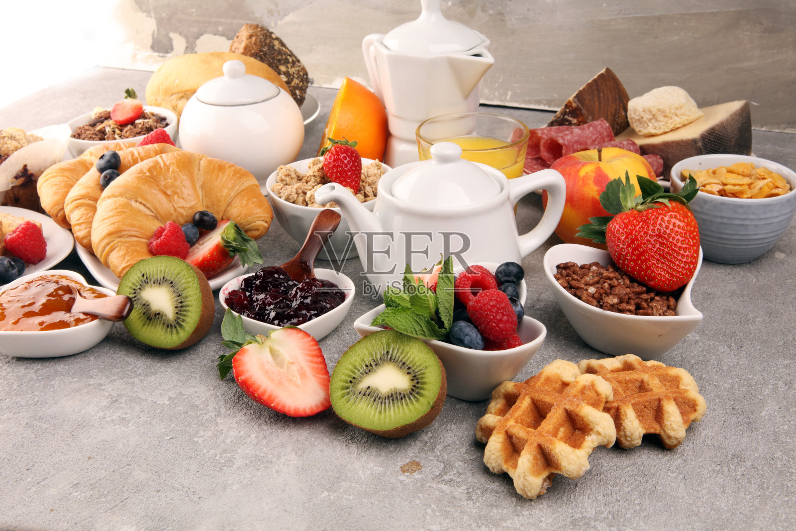 早餐包括咖啡、橙汁、羊角面包、麦片和水果。均衡的饮食。欧式早餐，格兰诺拉麦片和水果照片摄影图片