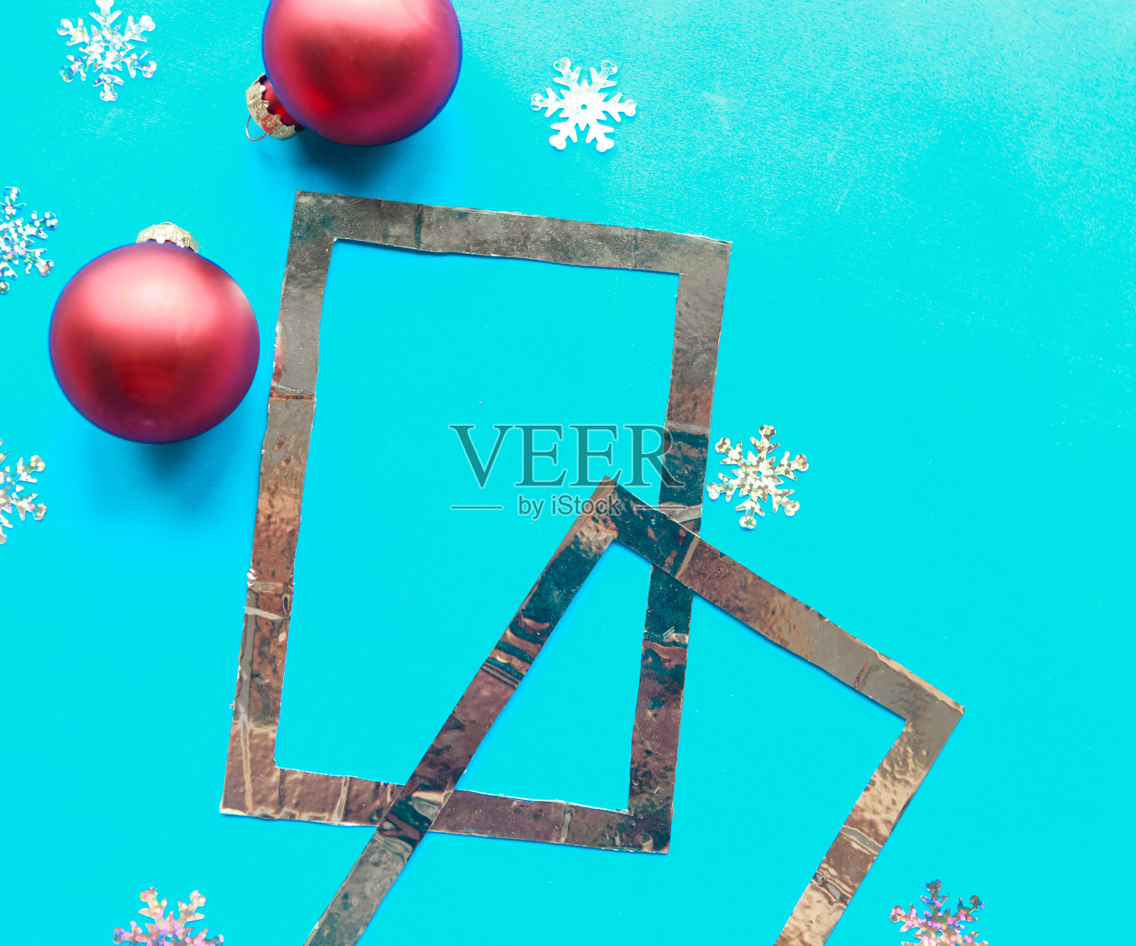 银色相框和明亮的蓝色背景上的圣诞装饰物。圣诞贺卡照片摄影图片