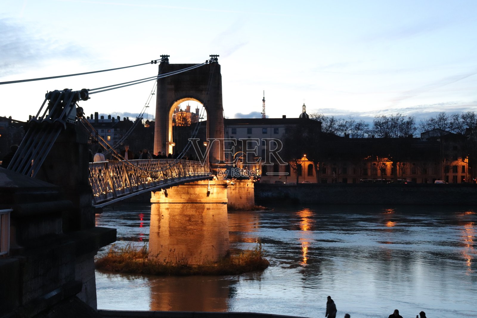 日落时分，里昂市Rhône河上的学院桥照片摄影图片