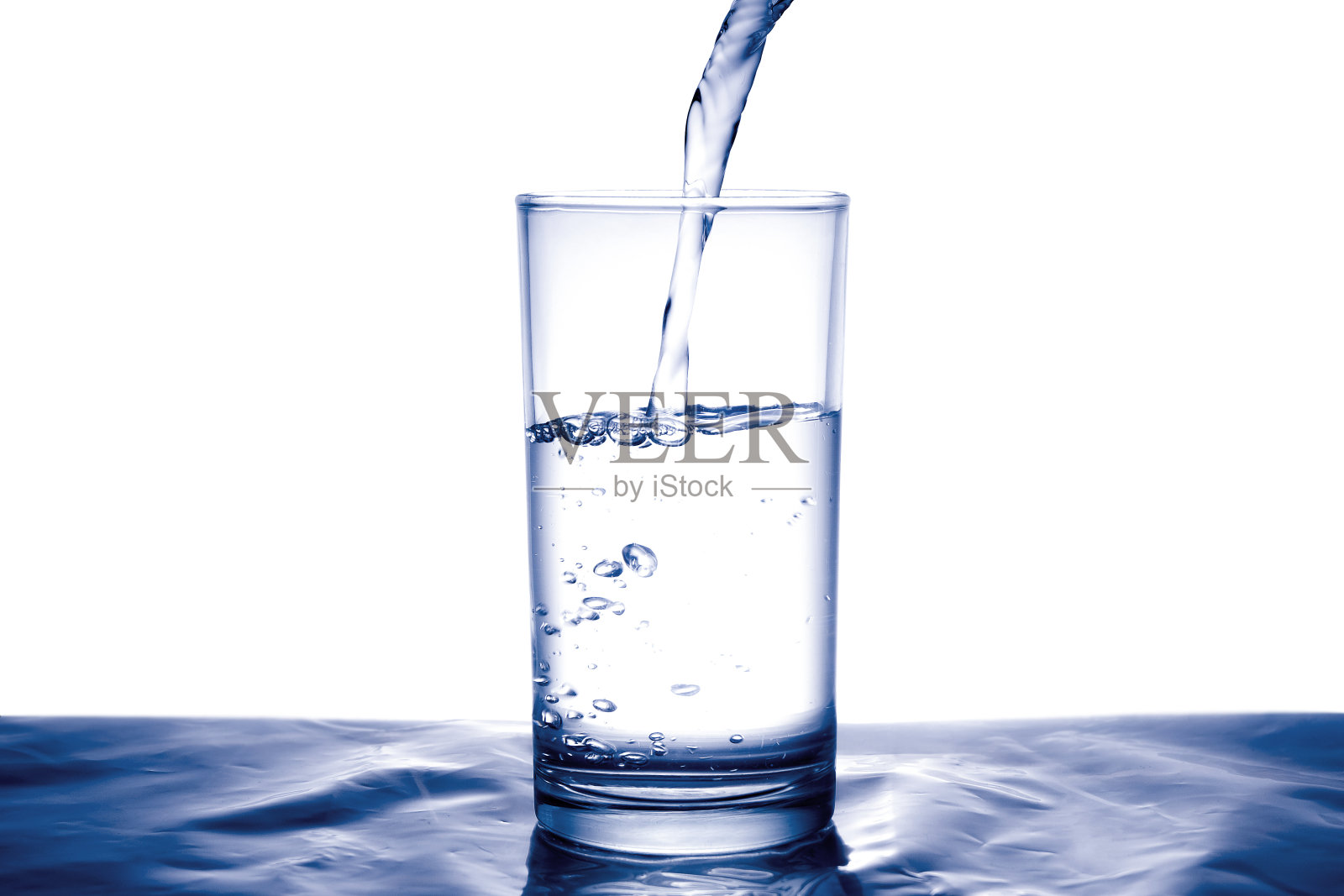 清洁的水有利于健康。将新鲜的纯净水从大水罐倒入木制桌子上的玻璃杯中。健康与饮食概念。生活保健与美容。照片摄影图片