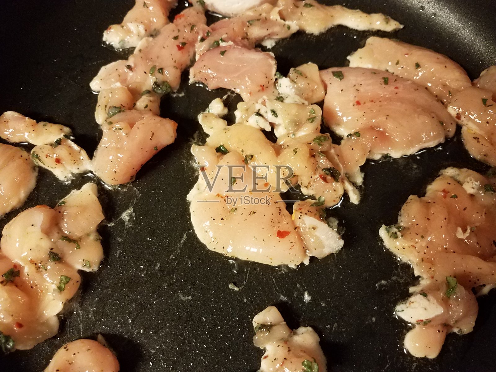 调味鸡肉在煎锅中烹饪照片摄影图片