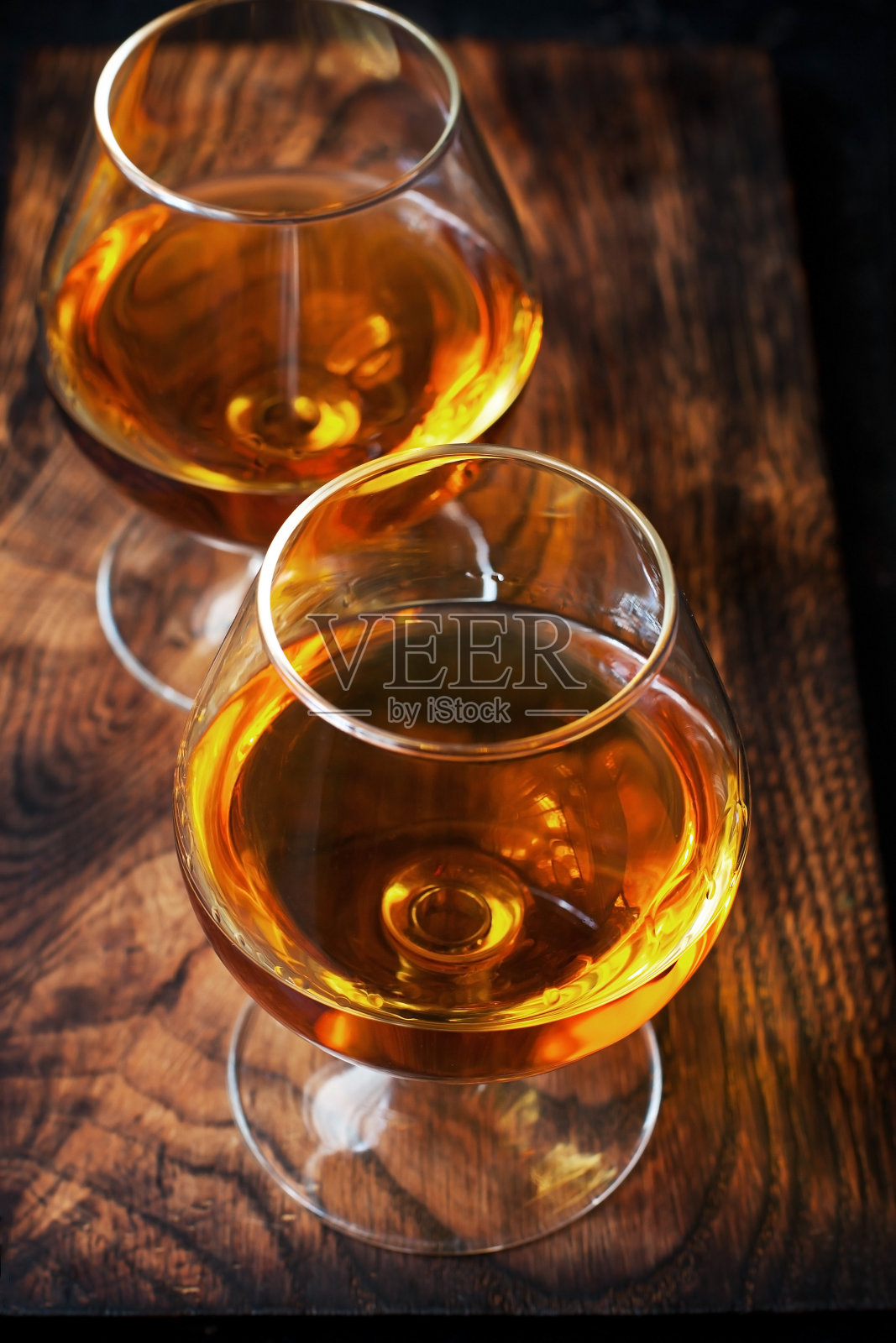 深色的桌子上放两杯白兰地或白兰地照片摄影图片