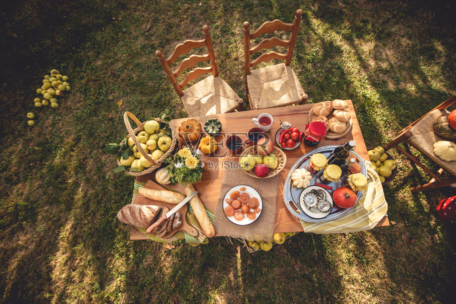餐桌上摆放着新鲜水果和自制糖果，摆放在阳光明媚的后院照片摄影图片