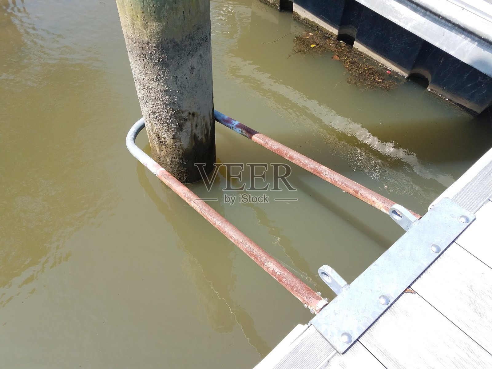 带水、金属钩和木杆的木码头照片摄影图片