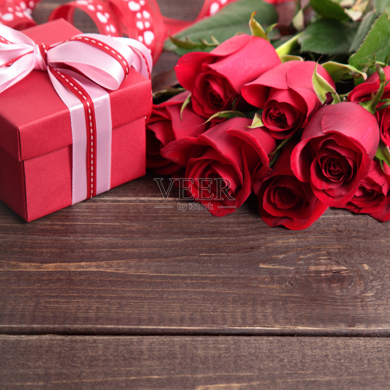 情人节背景礼物盒和红玫瑰上的木头。副本的空间。照片摄影图片