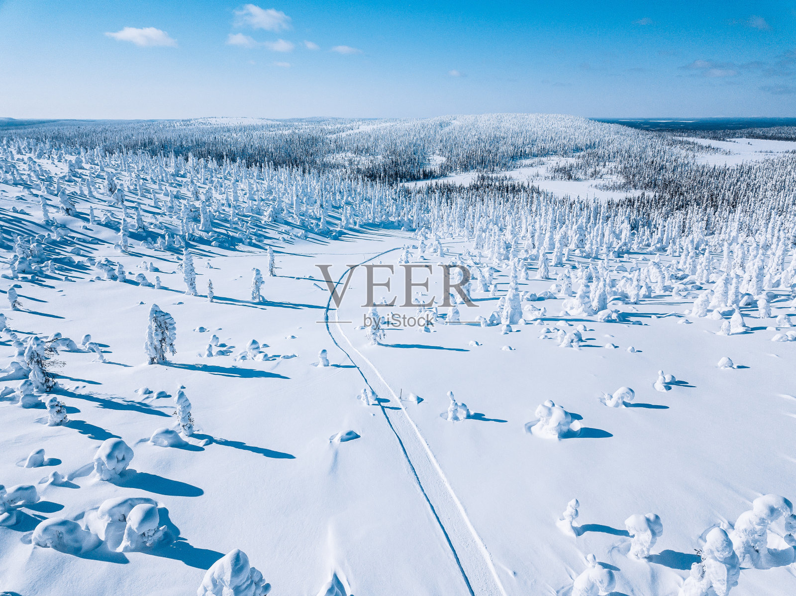 鸟瞰图白色的冬天森林与雪覆盖的树木和农村道路在芬兰照片摄影图片