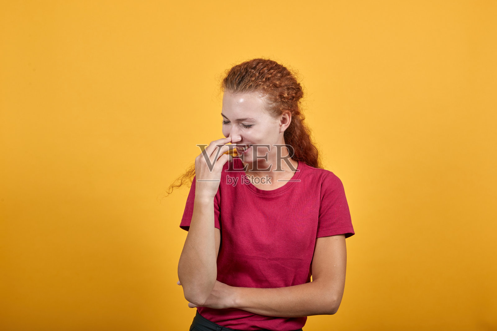 美丽的欧洲女孩笑着，用右手闭上她的嘴。照片摄影图片