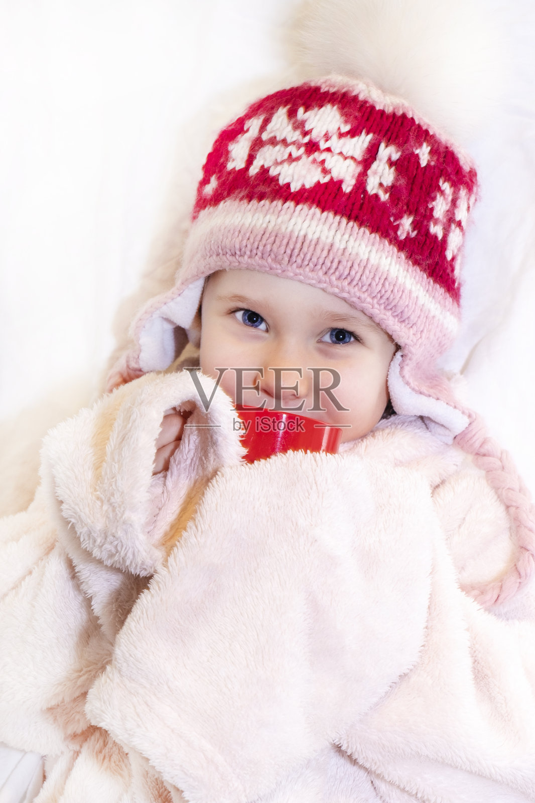 白色背景上戴绒球帽的欧洲女孩照片摄影图片