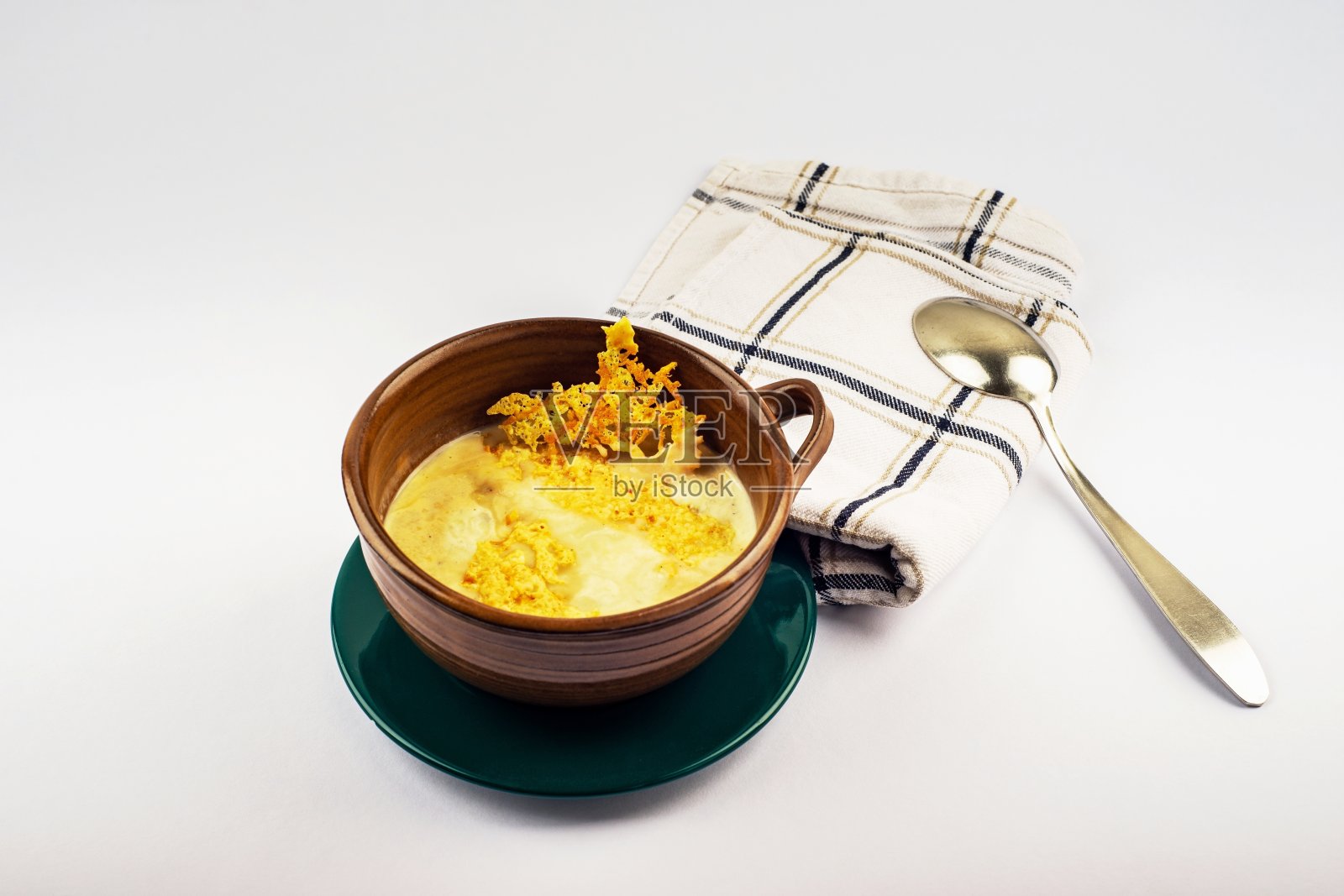 高达奶酪汤，勺子和毛巾。照片摄影图片