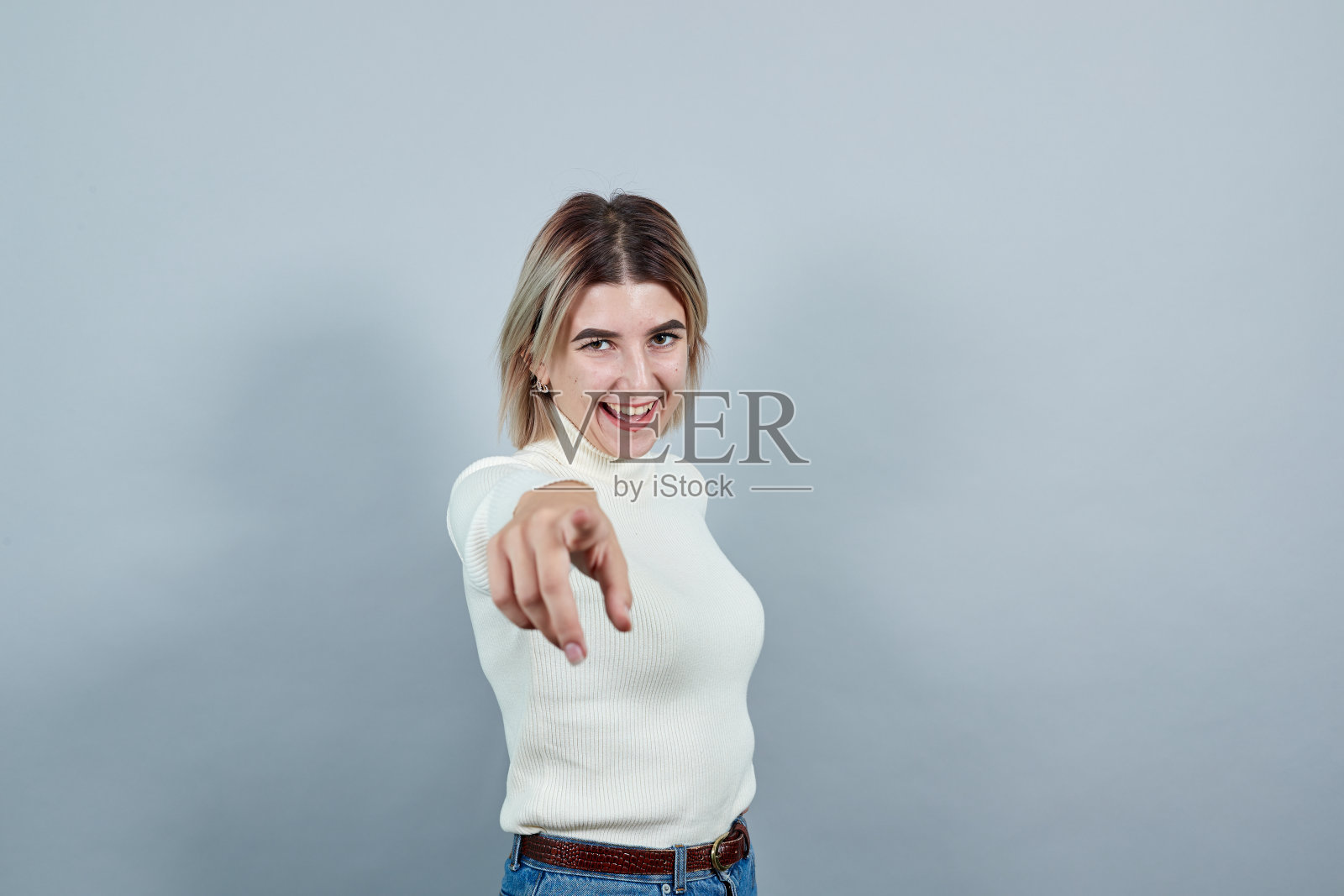 漂亮的年轻女士穿着毛衣停留指向他的手指直接照片摄影图片