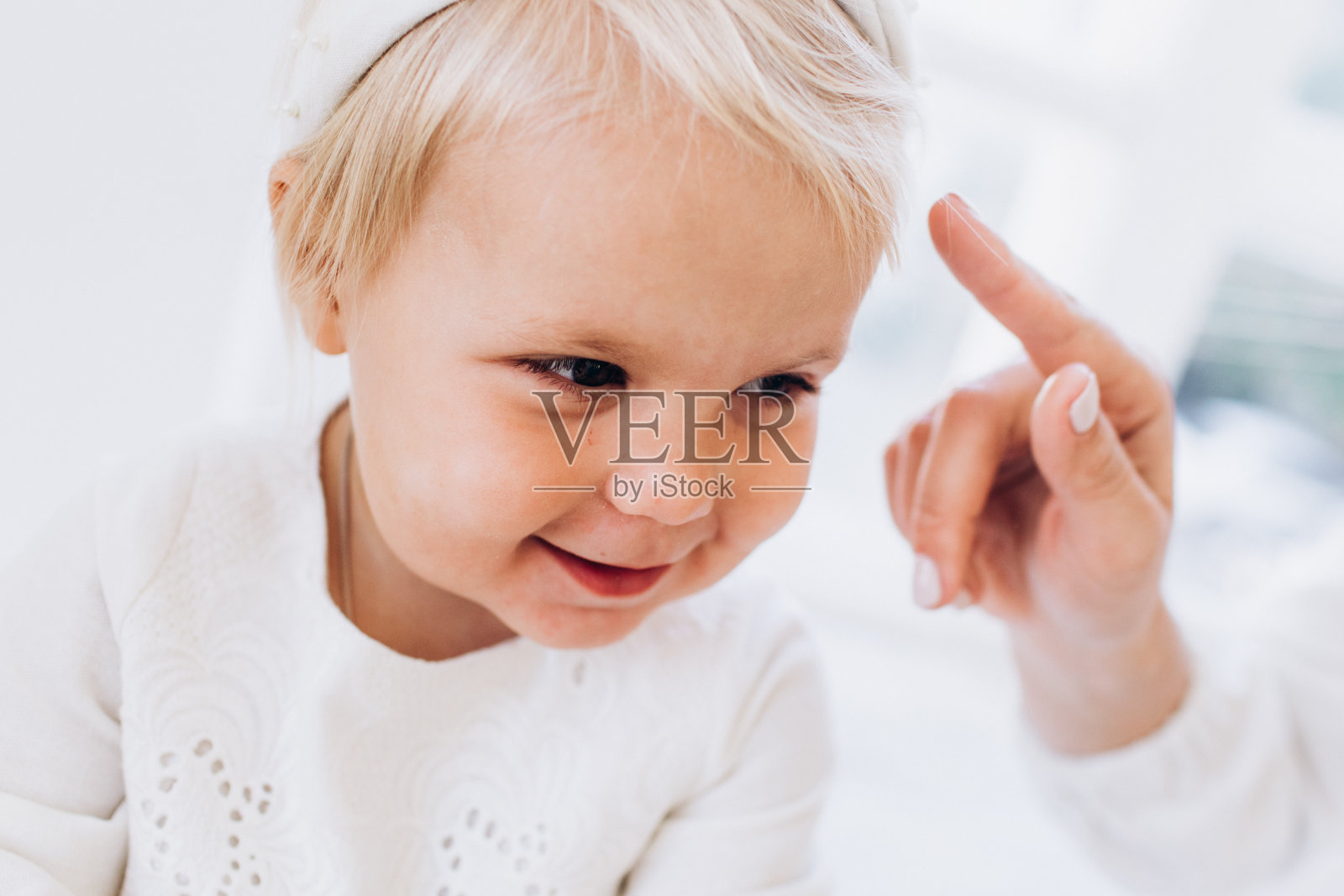 穿着白色衣服的小孩。一家人在和小女儿玩照片摄影图片