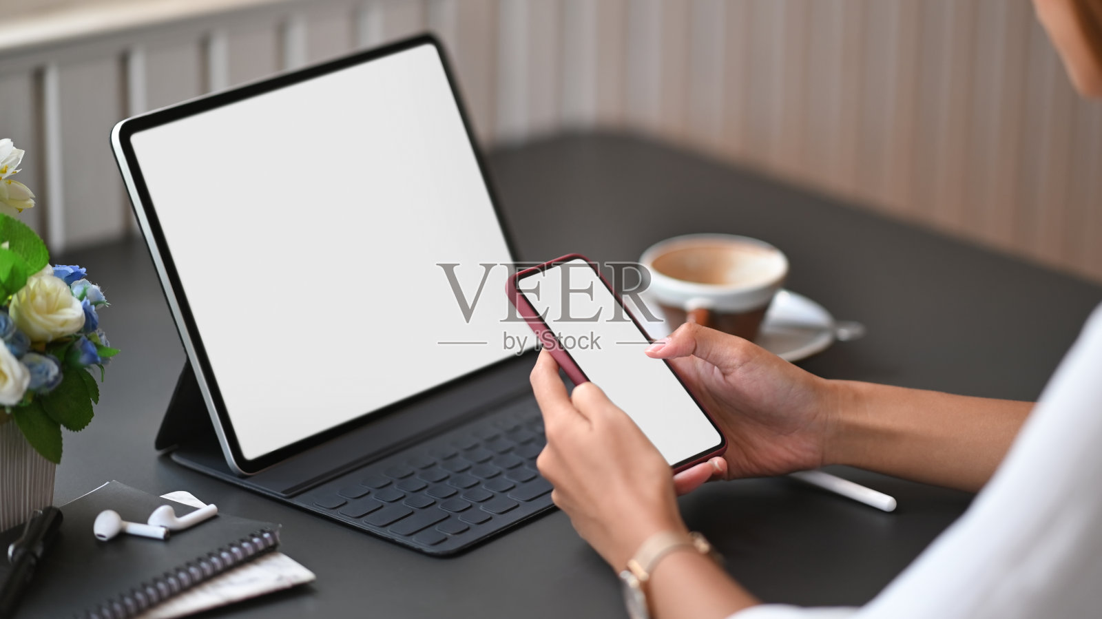 特写女性使用模拟智能手机在办公室工作空间。照片摄影图片