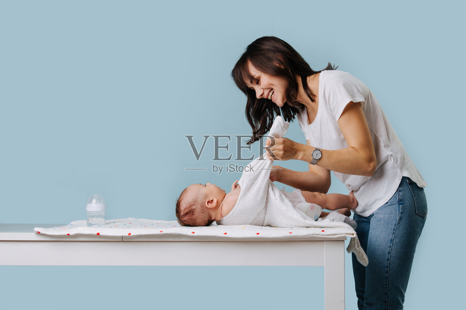 这位年轻的母亲照料她的婴儿照片摄影图片