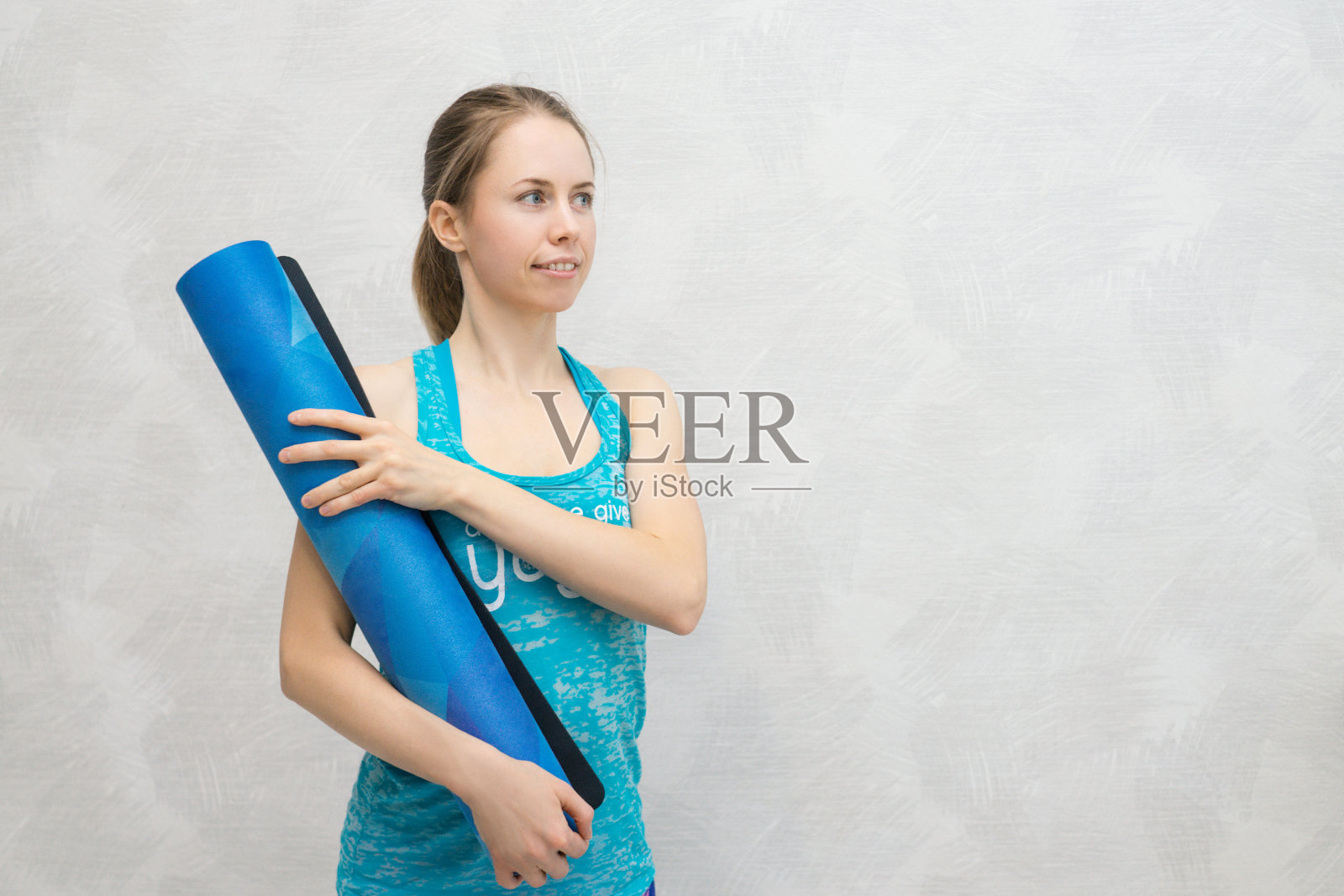 一个女人用垫子练习瑜伽。照片摄影图片