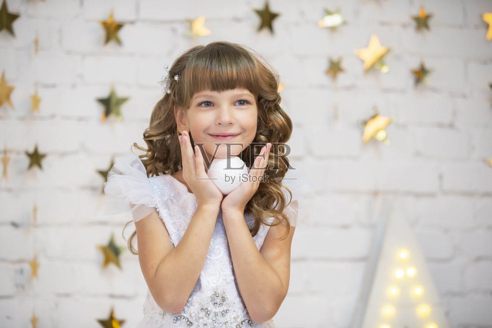 有圣诞舞会的漂亮孩子。穿着白色裙子的模特小女孩。聪明的女孩照片摄影图片