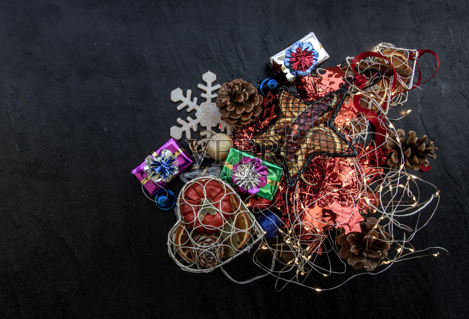 圣诞装饰。树枝圣诞树，棕色的天然松果和和圣诞鹿与各种水果在黑暗的背景。副本的空间。照片摄影图片