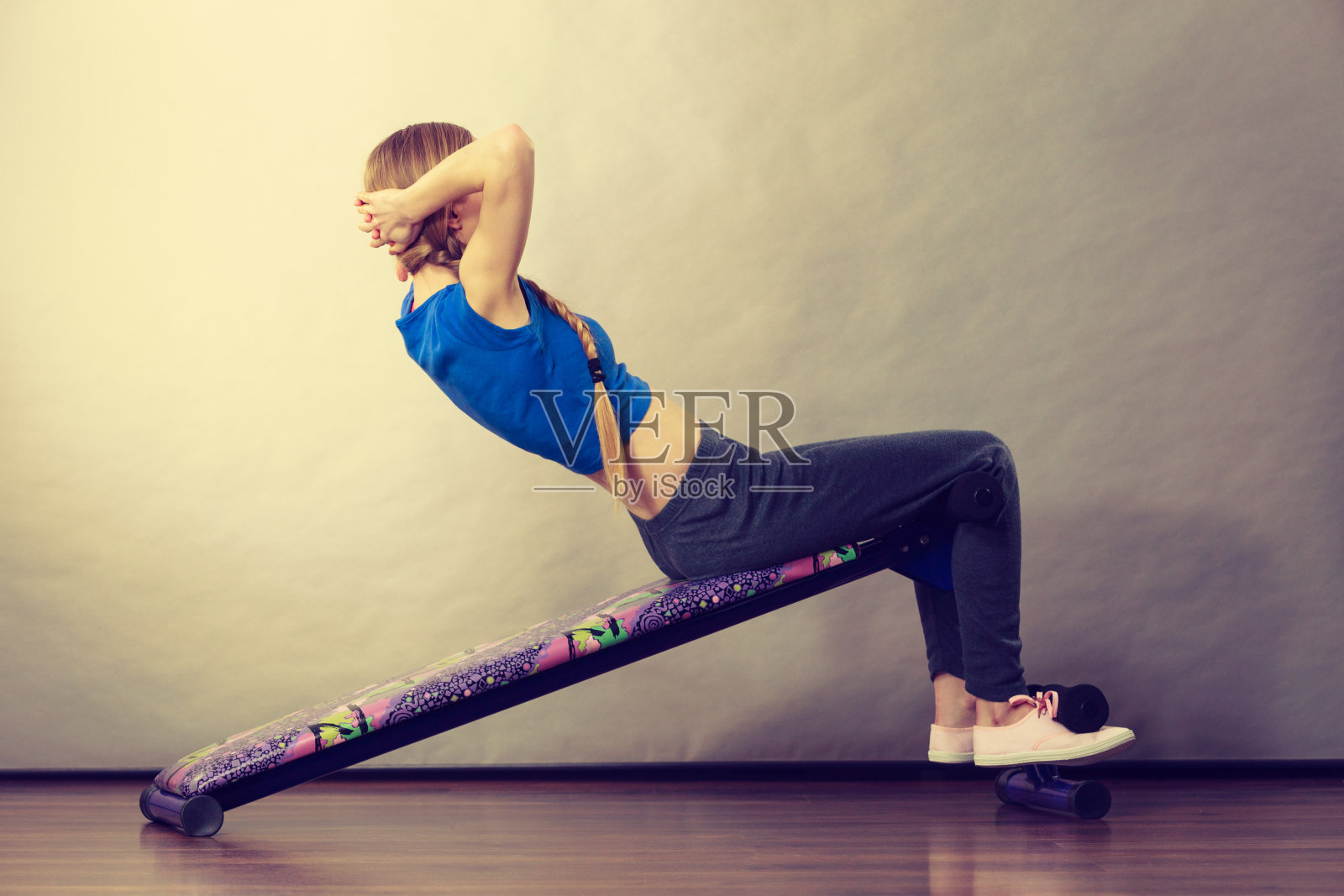 女子在长凳上训练仰卧起坐照片摄影图片