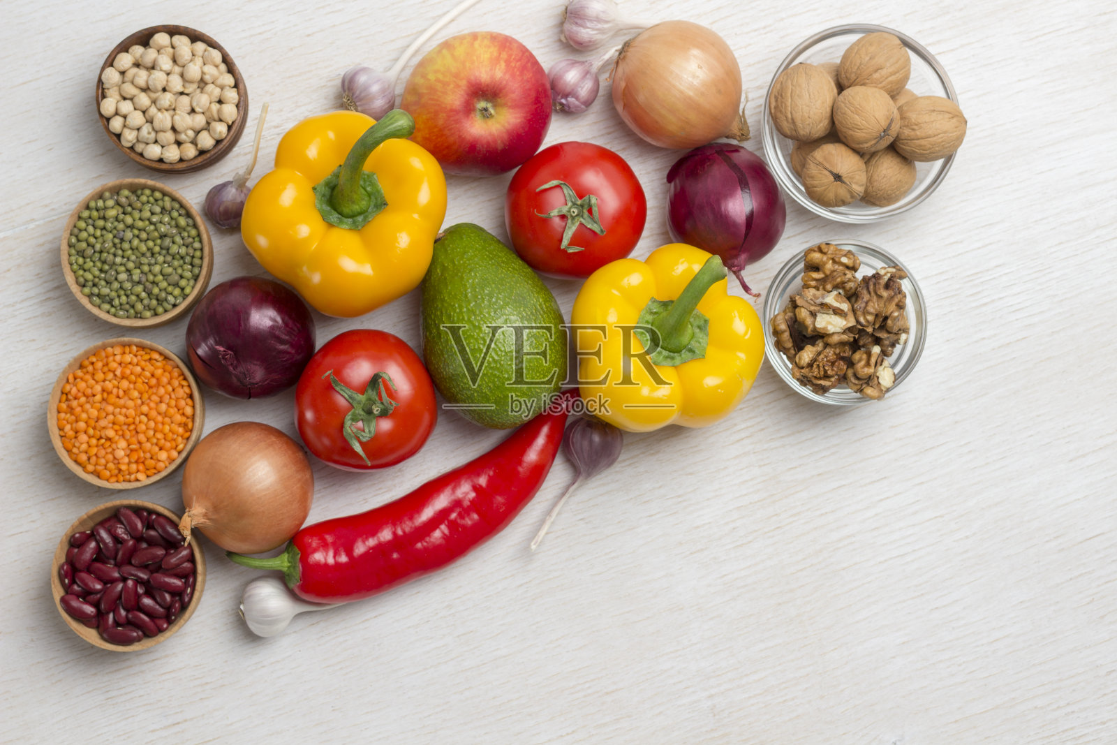 一套健康饮食的蔬菜，黄椒和红椒，牛油果，西红柿，洋葱，大蒜。俯视图，白色背景。这里有文本的位置照片摄影图片