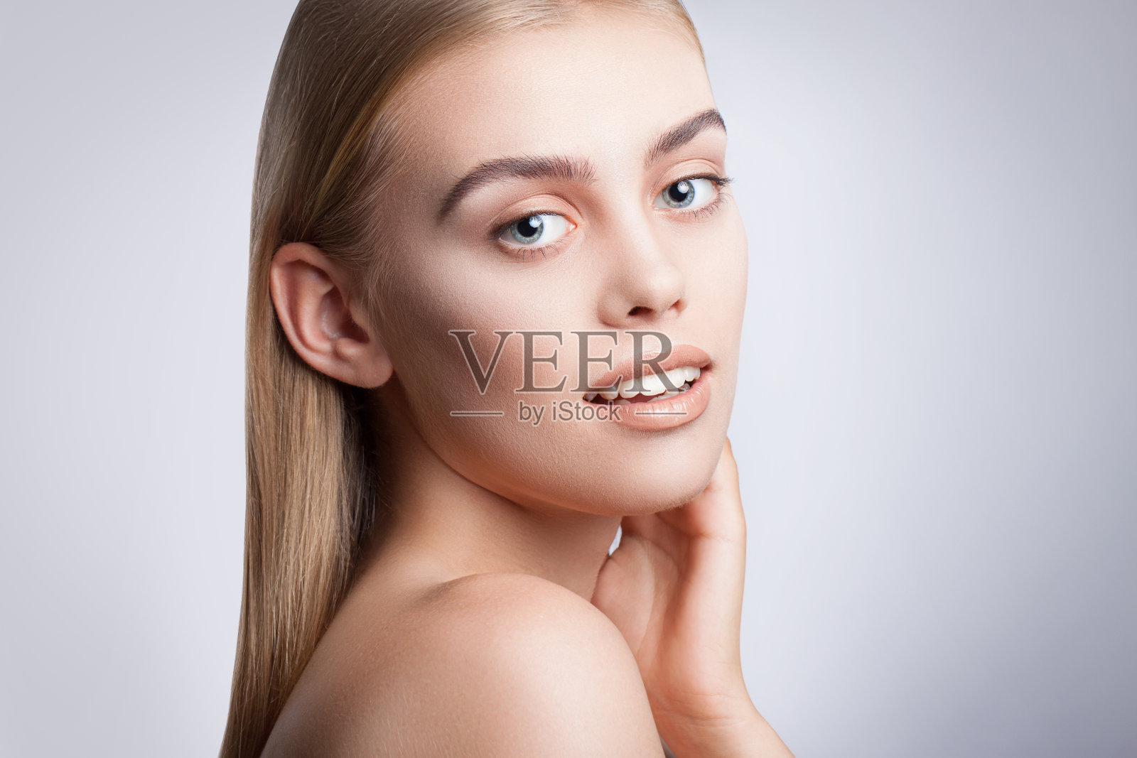 一个漂亮的蓝眼睛女孩的肖像。漂亮的妆容，光滑的头发，蓝色的眼睛，张开的手臂，完美的皮肤。照片摄影图片