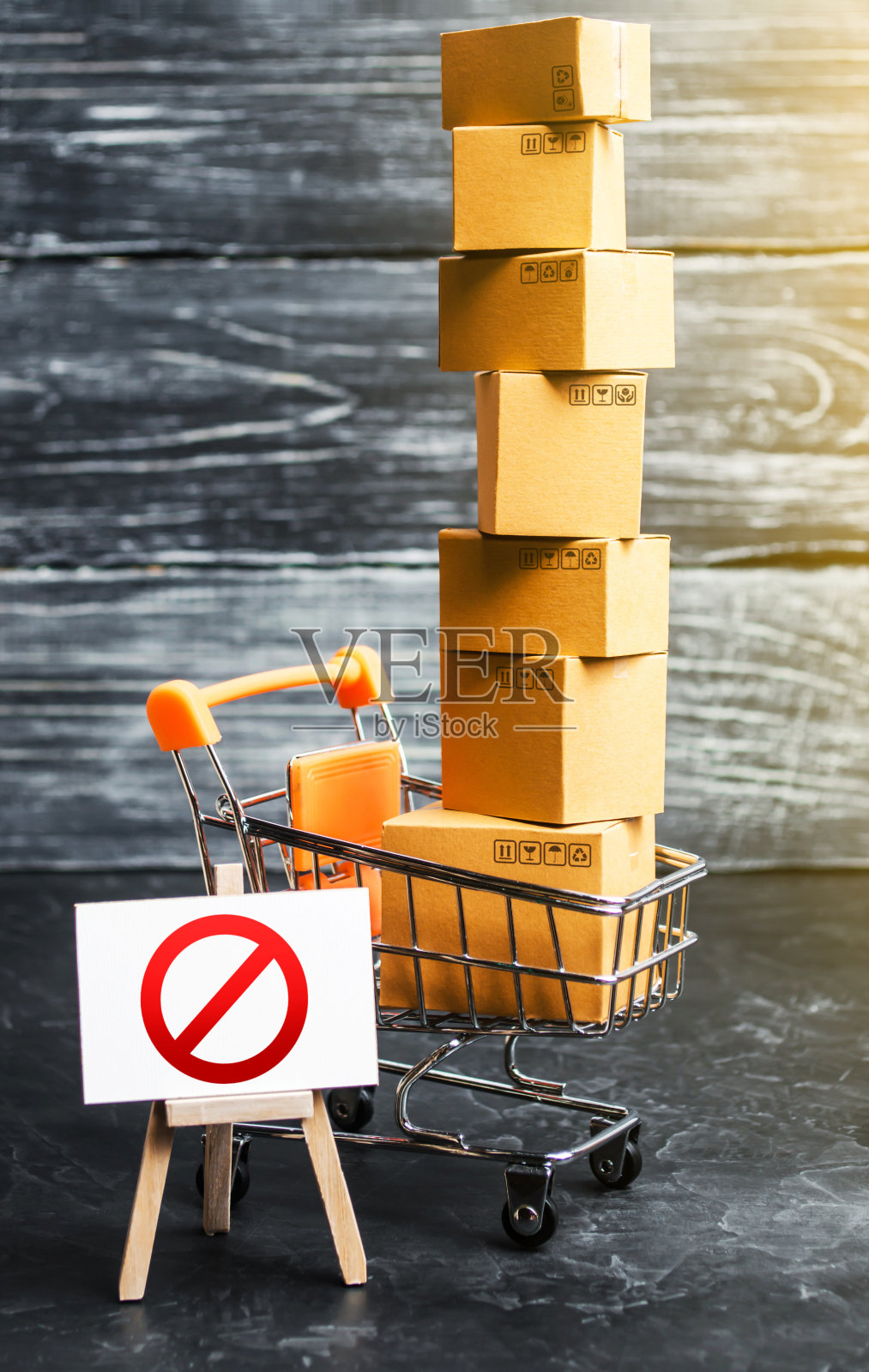 交易手推车与盒子和画架与禁止标志NO。网上交易禁止网上购物。进口货物限制，专有经营。制裁和经济限制照片摄影图片