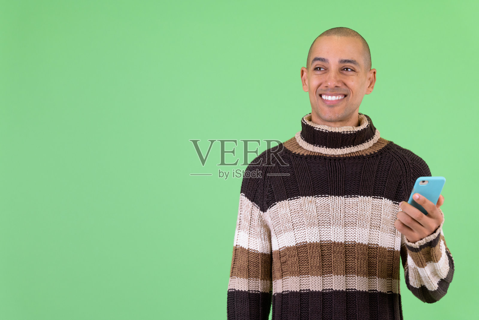 快乐的光头多种族男人在冬天使用手机思考照片摄影图片