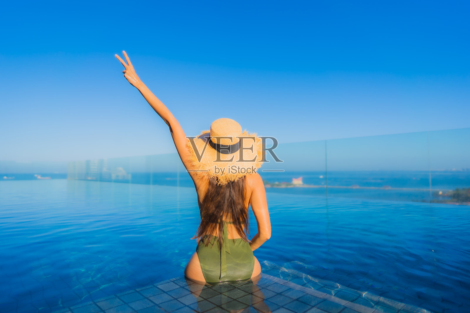 美丽的年轻亚洲女人快乐的微笑放松周围的户外游泳池在酒店度假旅游照片摄影图片