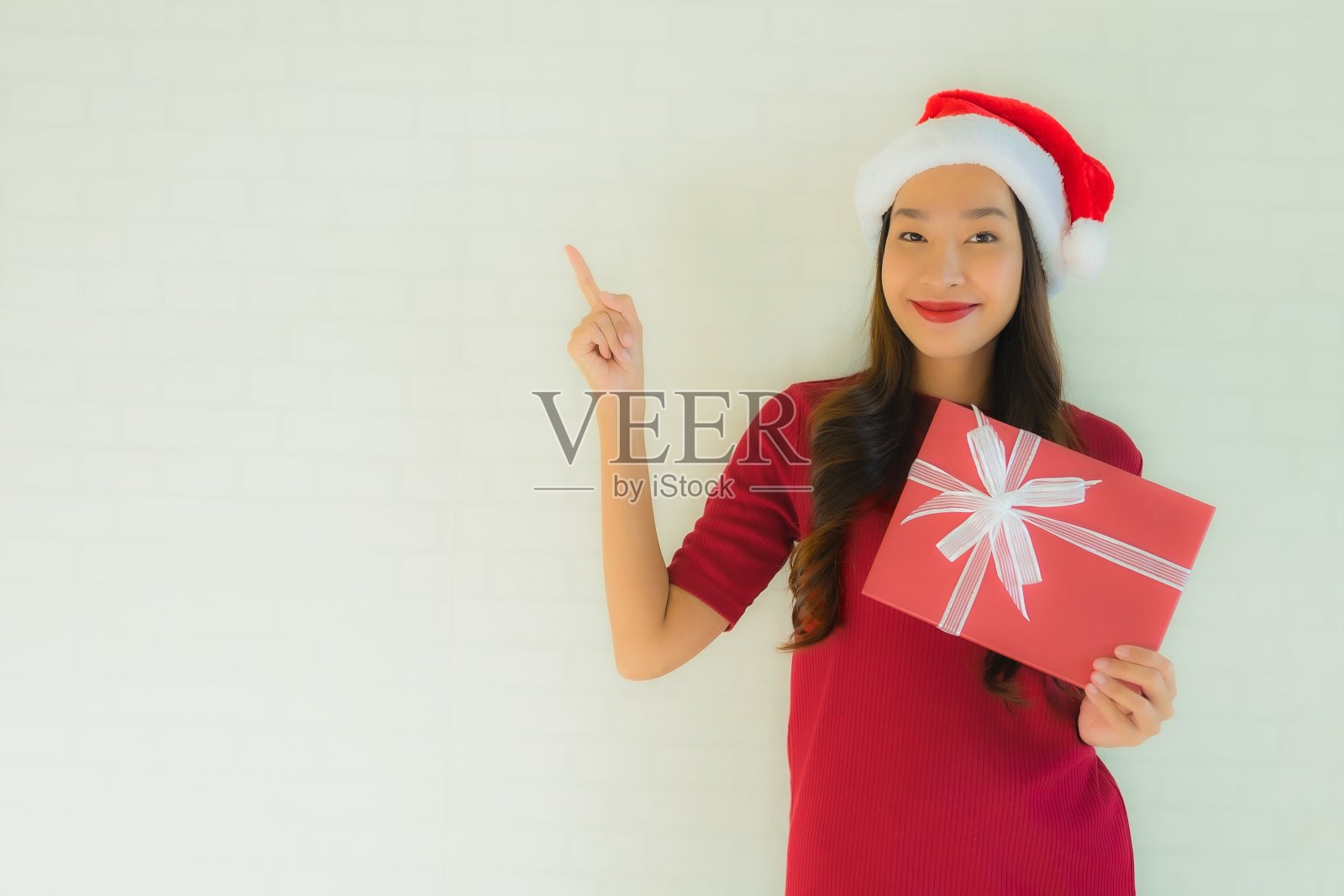肖像美丽的年轻亚洲妇女戴圣诞帽与圣诞礼盒照片摄影图片