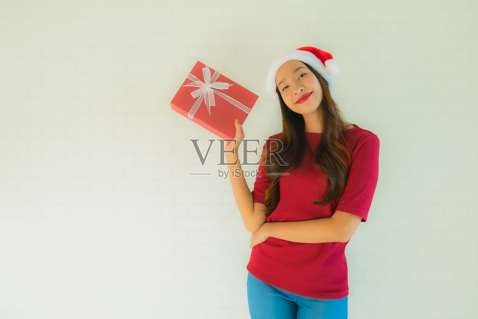 肖像美丽的年轻亚洲妇女戴圣诞帽与圣诞礼盒照片摄影图片