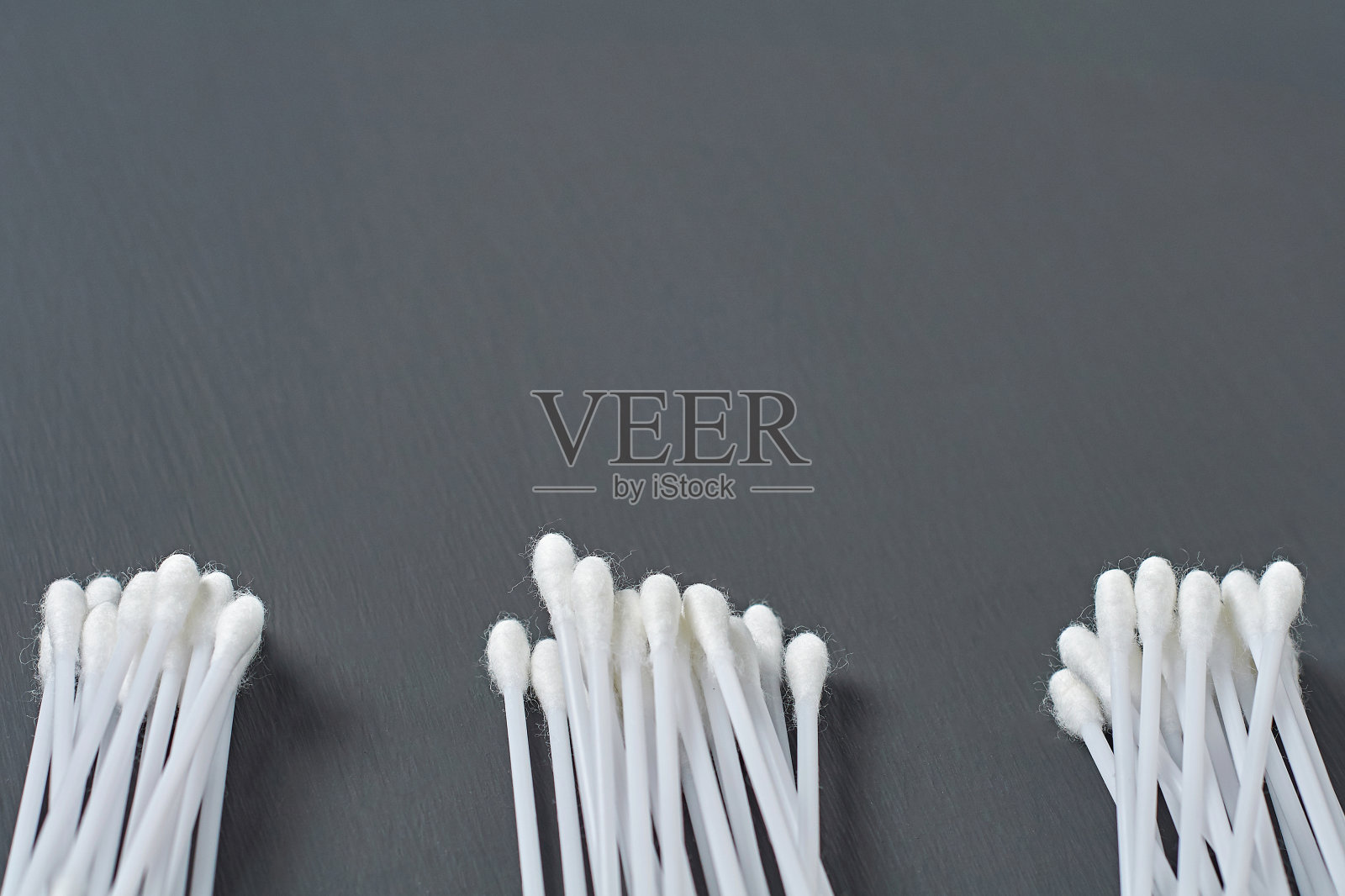 深色的水泥桌子上放着三堆新的卫生用棉条。空间的文本照片摄影图片