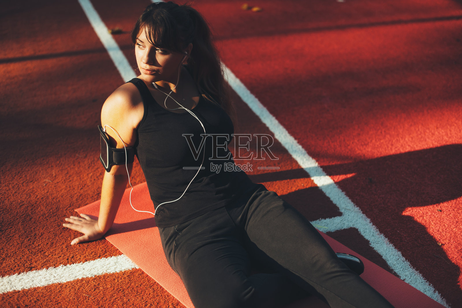 美丽的加码女人在做晨练后休息在户外减肥。照片摄影图片