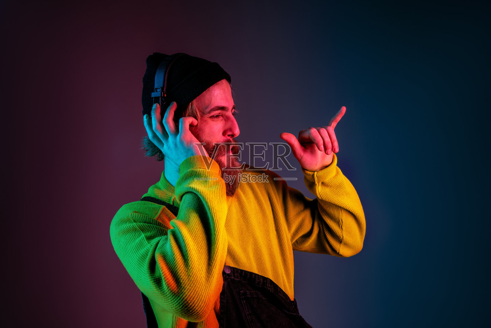 高加索人的肖像孤立在霓虹灯渐变工作室背景上照片摄影图片