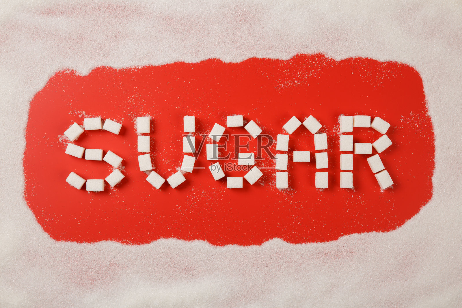 糖字由方块和砂糖框架在红色的背景照片摄影图片