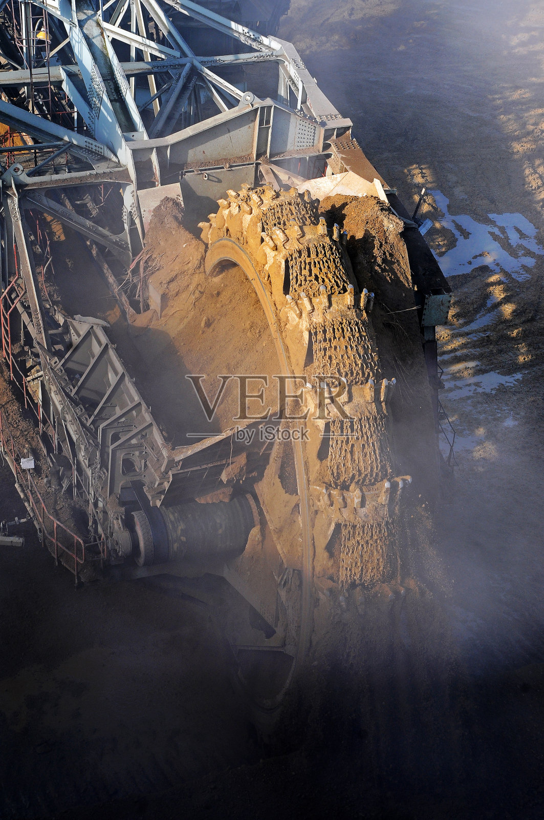 一个巨大的斗轮挖掘机在露天矿。挖掘机在雾中。照片摄影图片