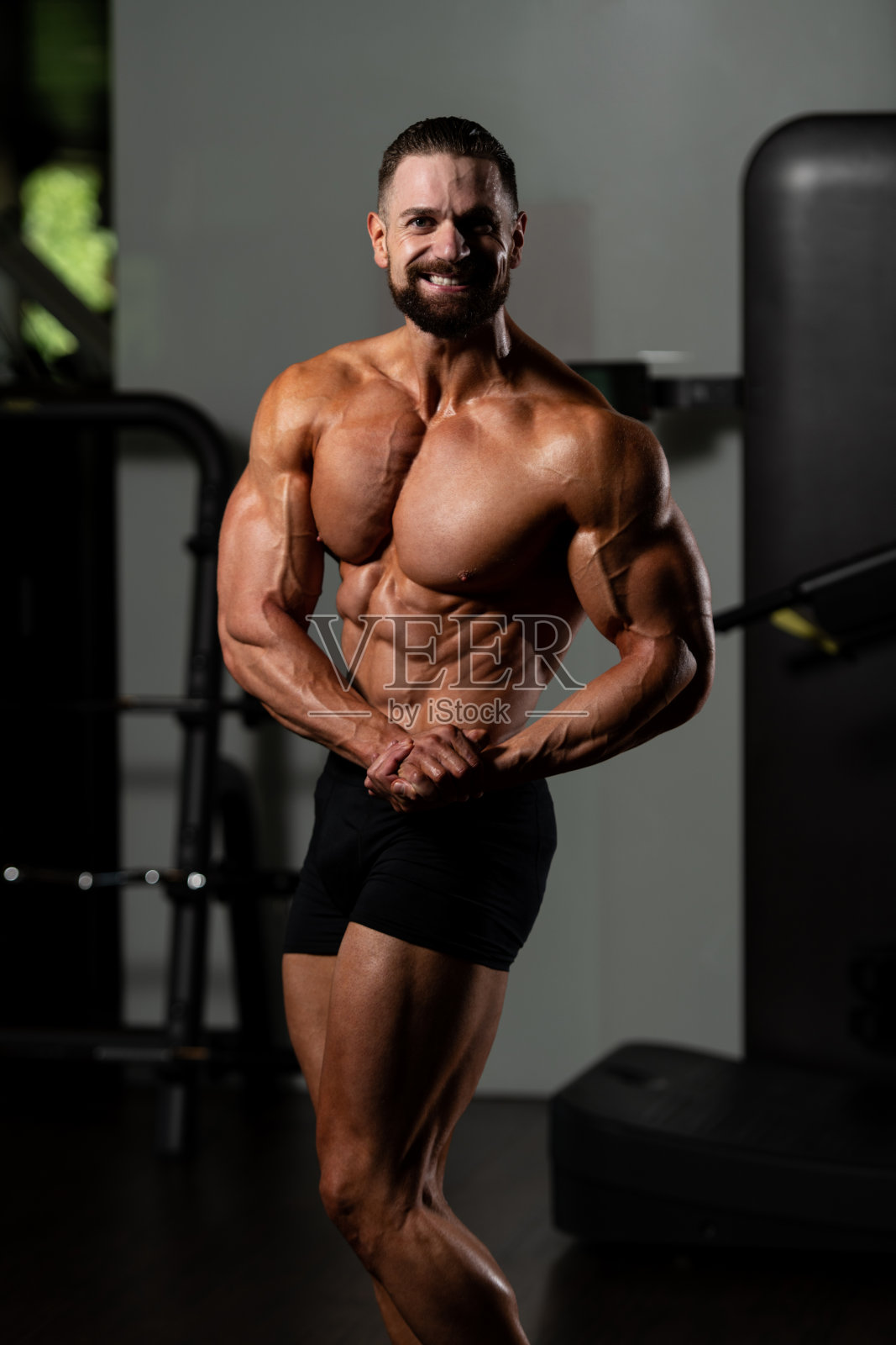 男人在健身房展示他训练有素的身体照片摄影图片