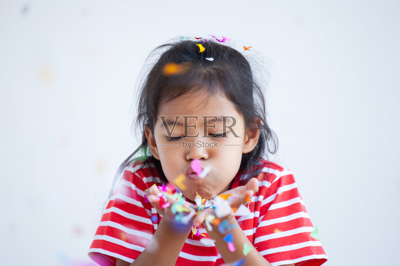 可爱的亚洲儿童女孩与五彩纸屑庆祝在她的派对照片摄影图片