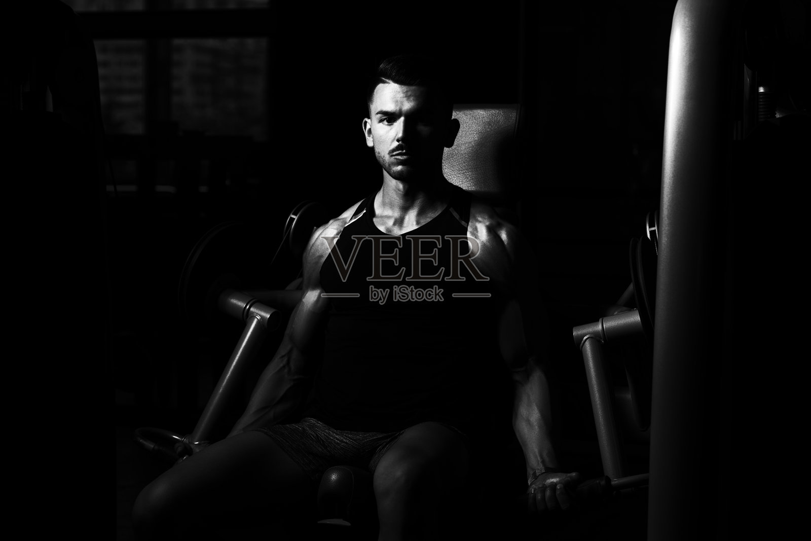 在健身房锻炼肩膀的男人照片摄影图片