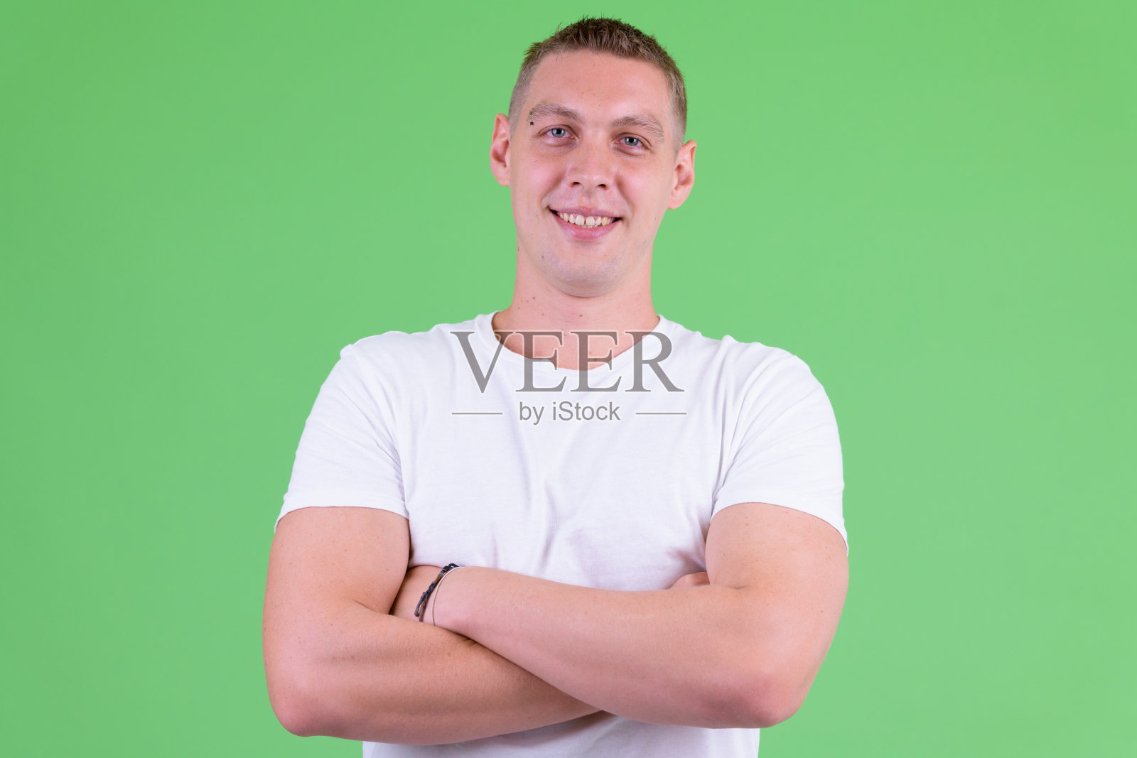 幸福的年轻人的肖像与双臂交叉微笑照片摄影图片