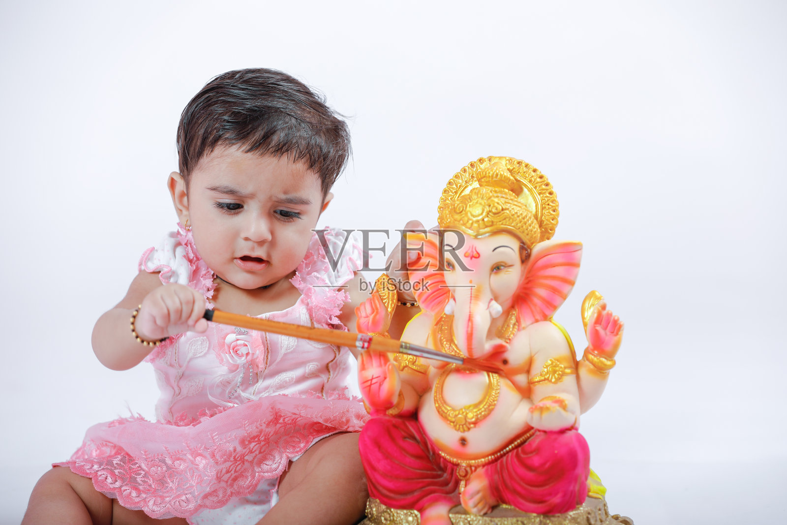 印度女婴与主甘尼沙祈祷，印度甘尼沙节照片摄影图片